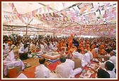 Swamishri and devotees perform arti in the yagna