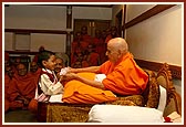 Swamishri talks to the child, gives him prasad...