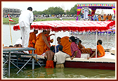 Swamishri sprinkles holy water on Mahant Swami
