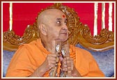 Swamishri devotionally plays the kartal in an assembly
