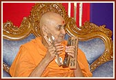 Swamishri devotionally plays the kartal in an assembly