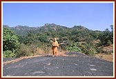 Swamishri with Shri Harikrishna Maharaj standing amidst the mountain range of Arbudachal