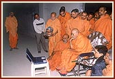 Swamishri views details of content of each section in Exhibition Hall 1 on a computer