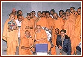 Swamishri views details of content of each section in Exhibition Hall 1 on a computer