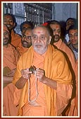 Swamishri plays the 'manjira' and joins in singing "Yogi avo te rang mane shid lagadyo..." before the murti of Brahmaswarup Yogiji Maharaj
