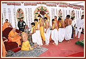 Swamishri ritually performs the janoi ceremony and pleases them with a group photo