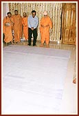 Swamishri looks at the plan of Jaipur shikharbaddh mandir
