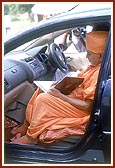 Swamishri writes his blessings in a car