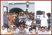 Swamishri performs his morning puja indoors in the confined space of a house because it was raining outside