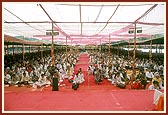 The participant devotees (yajmans) perform arti