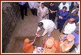 During the foundation-stone laying ceremony for the hostel of Hiramani School, on behalf of Swamishri, Pujya Ishwarcharan Swami performs the rituals