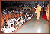 Swamishri blesses the devotees of Nenpur and Sankhej by showering rice grains after the pratishtha rituals