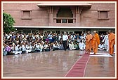 Swamishri humbly responds to the children and devotees while returning to his quarters