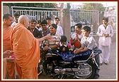 While performing pujan of a motorcycle Swamishri talks to children