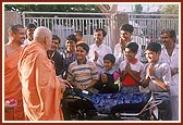 While performing pujan of a motorcycle Swamishri talks to children