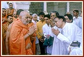 On his way for Thakorji's darshan, Swamishri humbly responds to the devotees