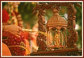 Swamishri sprays colored water on Shri Harikrishna Maharaj