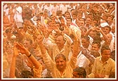 Swamishri sprays colored water on elated devotees and sadhus 