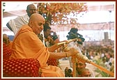 Swamishri sprays colored water on elated devotees and sadhus 