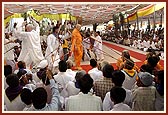 Devotees of Badalpur play the traditional trumpets and dance during Swamishri's morning walk