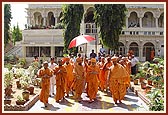 Swamishri walks towards the assembly hall after having darshan of Thakorji