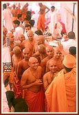 The parshads leave the stage to change from their white robes into their saffron robes
