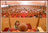 Swamishri and the parshads and sadhaks raise the new janois during the initiation ceremony