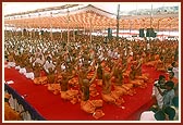 Swamishri and the parshads and sadhaks raise the new janois during the initiation ceremony