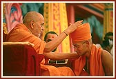 Swamishri blesses and gives the guru mantra to the newly initiated sadhus 