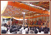 Swamishri and sadhus seated on the stage during the pratishtha assembly