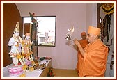 Swamishri performs arti of Thakorji in the school prayer hall