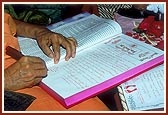 Swamishri writes his blessings in the mandir account books on Chopda Pujan day