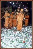 Swamishri showers flower petals and sanctifies the devotees' account books