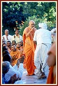 Swamishri performs pradakshina at the Yagnapurush Smruti Mandir with devotees in a joyful mood