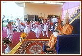 After his puja Swamishri participates by playing 'ghughra' while devotees of Badalpur sing bhajans