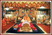 In the background of Swamishri's puja are murtis and sinhasans of kutir (hut) mandirs constructed in the interior villages 