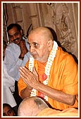 Swamishri offers his respects to Thakorji and is then welcomed with a garland