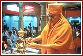 Swamishri ties a nada-chhadi on Shri Nilkanth Varni's wrist