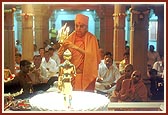 Performs the murti-pratishtha arti