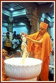 Swamishri performs the first abhishek of Shri Nilkanth Varni
