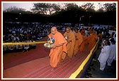 Pujya Tyagvallabh Swami and other sadhus bring six murtis of Shri Harikrishna Maharaj onto the stage