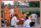 Swamishri observes the site plan on the land for the new BAPS Swaminarayan Mandir  