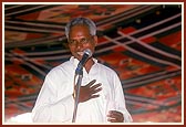 A tribal volunteer (devotee) addresses the assembly