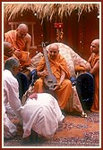 &nbsp;&nbsp;Swamishri plays and sanctifies an 'ektaro' of a tribal devotee