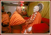 Swamishri arranges the garland of Shastriji Maharaj