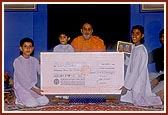 Children of BAPS Bal Mandal, Surendranagar, present Swamishri with a cheque of their savings
