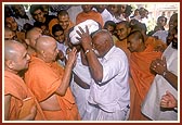 Swamishri is still weak after his fever. Shri Ragha Bharwad performs a traditional ritual of transferring Swamishri's illness onto himself by taking out his pagh and circling it around Swamishri's head 