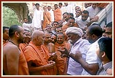 While on his way to the rang mandap Swamishri converses with Ragha Bharwad