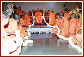 Sadhus offer a garland to Swamishri