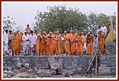Swamishri places a stone in the foundation pit and offers his service